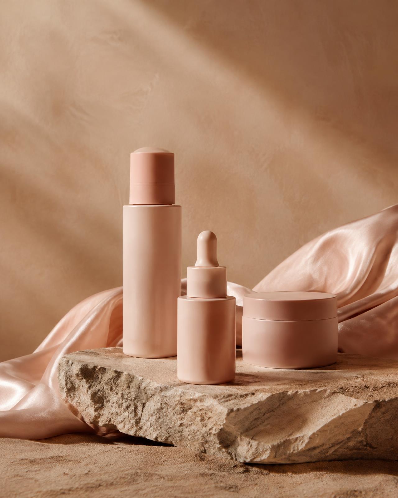 Blush skincare bottles on stone